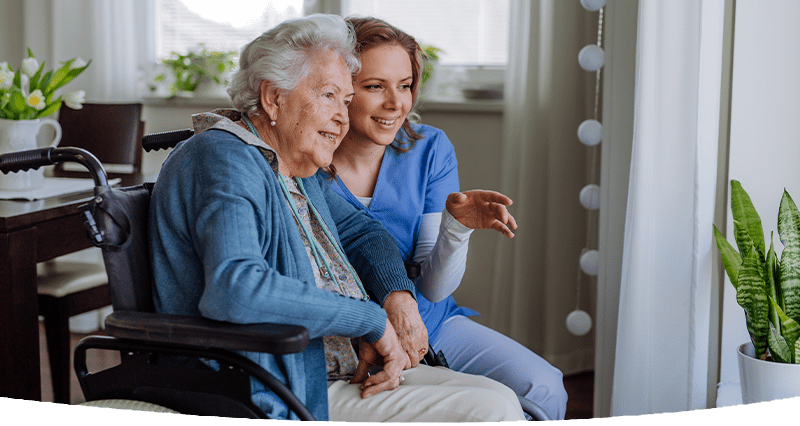 An elderly lady in a wheelchair being cared for by a support worker